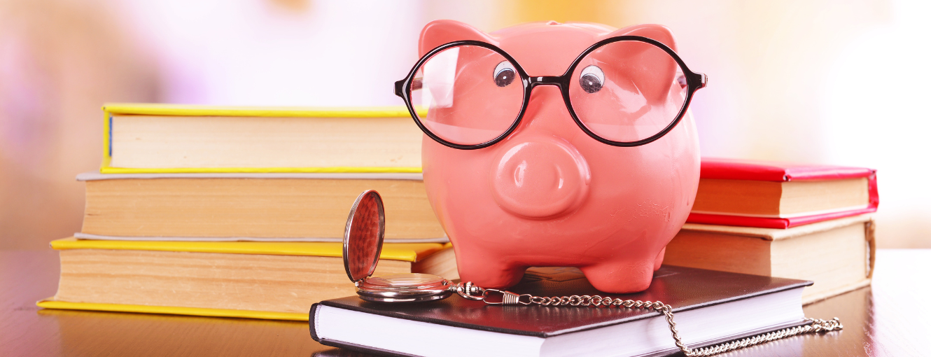 Piggy Bank with reading glasses sitting on books 