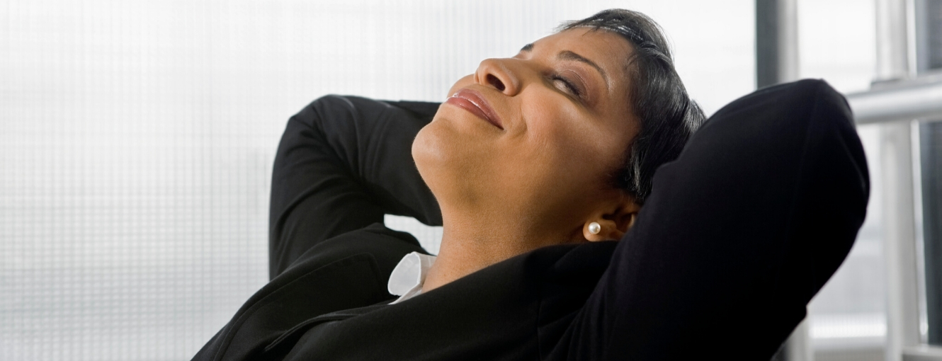 Woman smiling and leaning back in her office chair