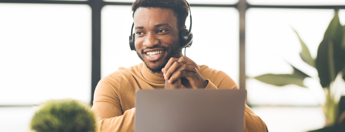 Man wearing a headset in front of a laptop