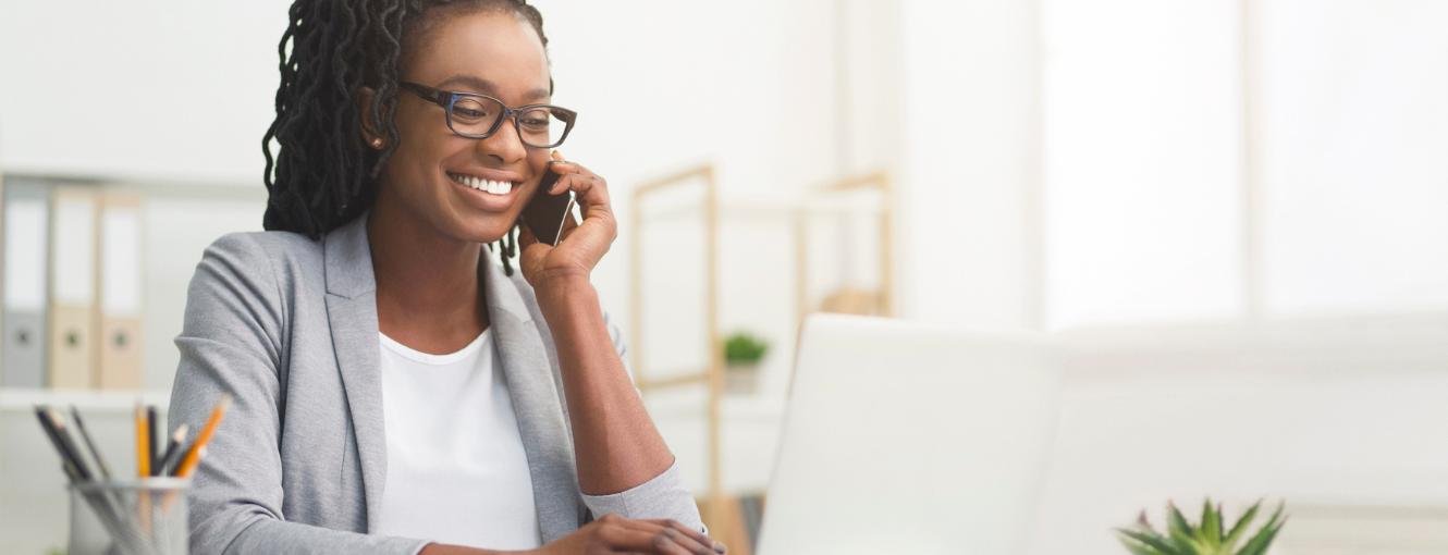 A woman talking on the phone and looking at a computer 