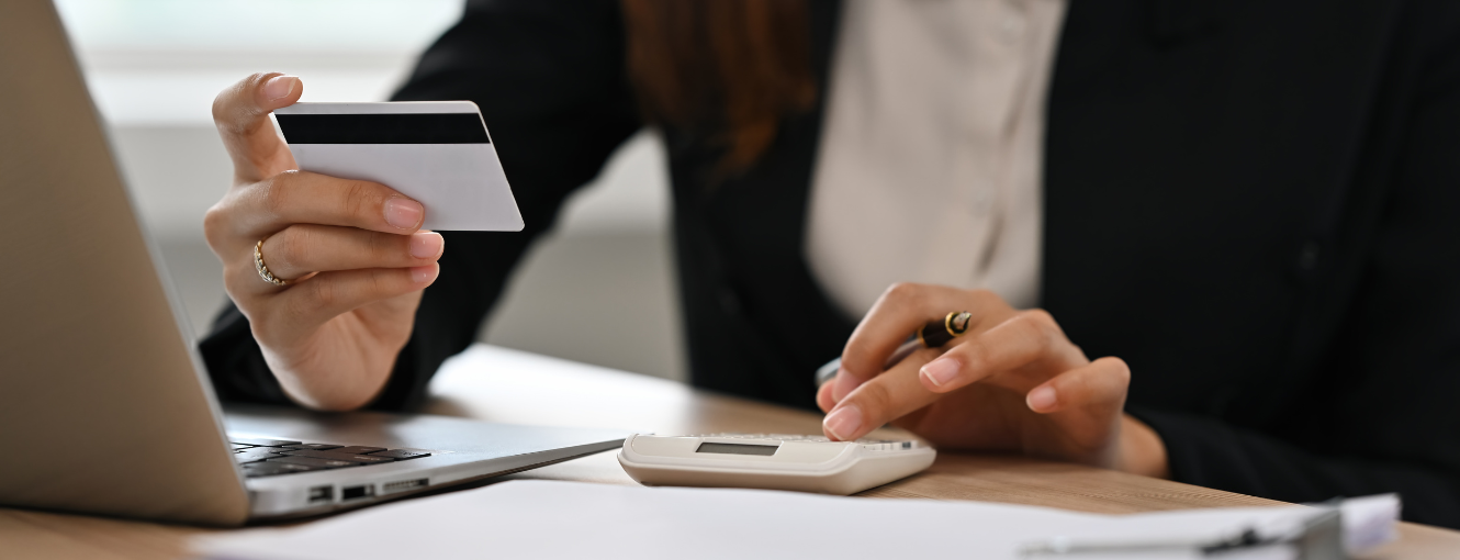 A business women in front of a laptop using a credit card