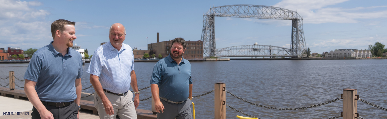 Business Bankers walking in front of the Duluth Lift Bridge.