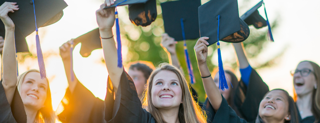 Students tossing graduation caps